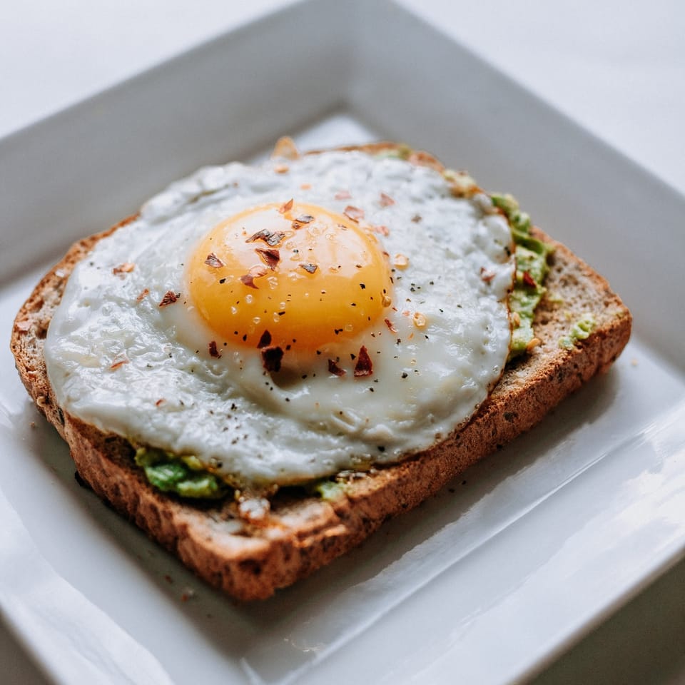 bread with sunny side-up egg served on white ceramic plate